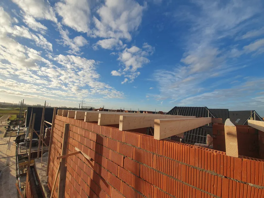 Rode bakstenen muren van een nieuwe woning in aanbouw.