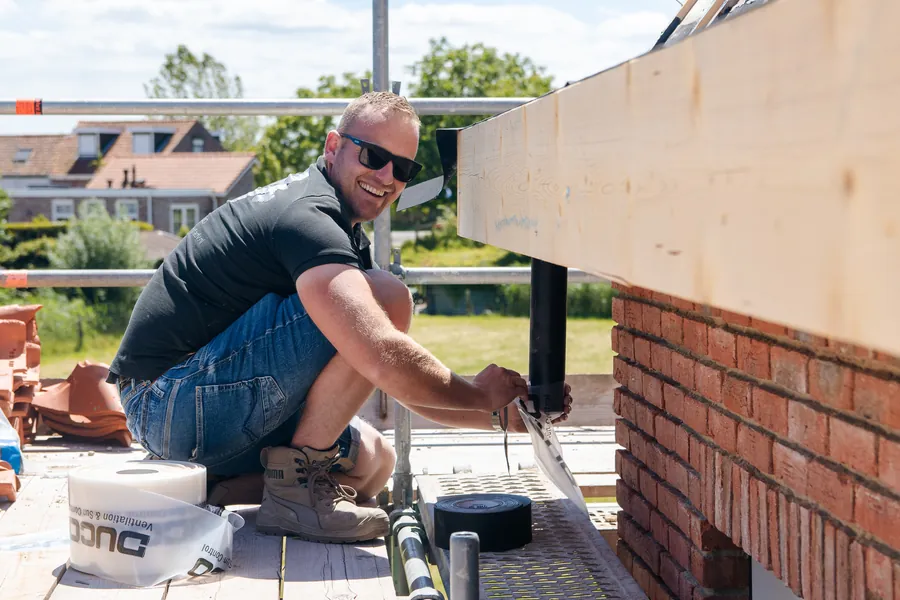 Een vakman van ADV verwerkt gevelsteen aan een aanbouw.