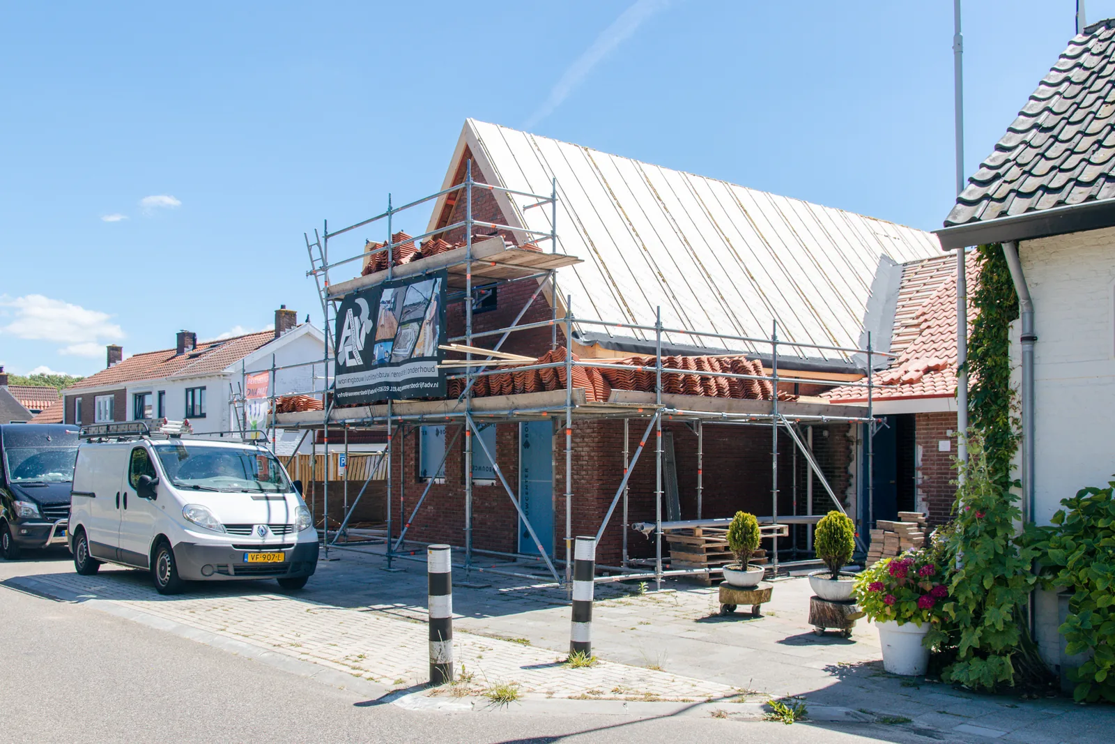 Een woning in de steigers tijdens een renovatie, met nieuwe dakplaten.